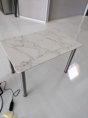 une table avec un plateau en marbre posée sur un sol carrelé