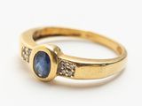Gros plan sur une bague en or ornée d'un saphir bleu