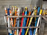 a rack of baseball bats and other baseball equipment in front of a wall
