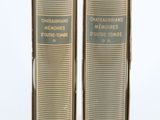deux vieux livres dans une boîte en carton posée sur une surface blanche