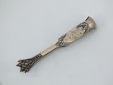 silver plated spoon with floral design on it on a white surface