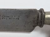 a close up of a knife on a white surface