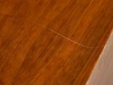 a close up of a wooden table with a cat on top of it