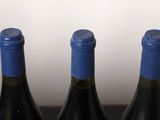 four bottles of wine are lined up on a table
