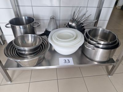 many pots and pans sitting on a stainless steel shelf