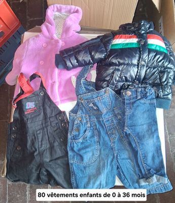 a pile of clothes sitting on the floor next to a box