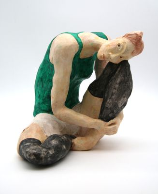 a figurine of a man kneeling on a rock