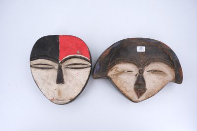 paire de masques en bois représentant des visages rouges et noirs sur fond blanc