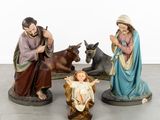 three figurines of jesus and a baby jesus in a manger