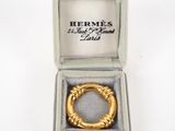 a close up of a gold ring in a box on a white surface