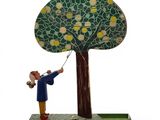 figurine of a man holding a kite in front of a tree