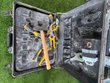 une valise contenant des outils, posée sur l'herbe