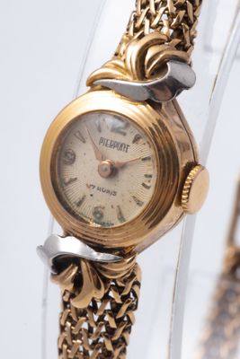 une montre-bracelet en or avec une chaîne autour d'elle