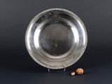 an antique silver plate with beaded edge and a small nut