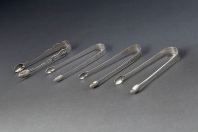 six cuillères et un repose-cuillère alignés sur une table