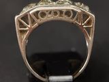 a close up of a gold ring with a green stone in it
