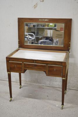 a small desk with a mirror on top of it
