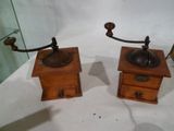 une paire de moulins à café anciens en bois exposés dans une vitrine