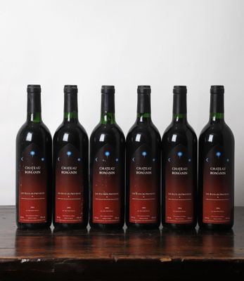 six bouteilles de vin sont alignées sur une table en bois