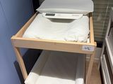 a small wooden shelf with towels on top of it