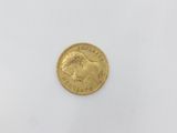 a gold coin on a white surface