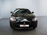the front of a black sports car is parked in a room