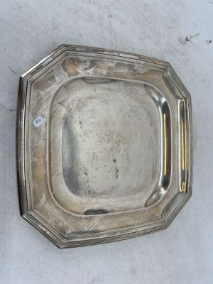 une assiette en argent avec un manche en argent sur un fond blanc
