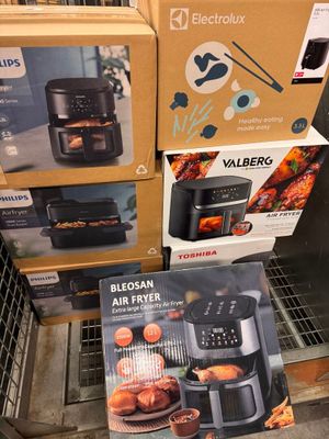 Plusieurs cartons contenant des friteuses à air chaud sont empilés les uns sur les autres