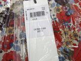 a tag on a floral shirt that is wrapped in plastic