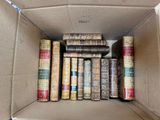 many old books in a cardboard box on the floor