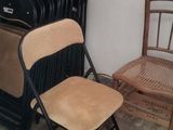 a stack of chairs next to a stack of suitcases