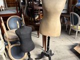 un mannequin assis sur une table à côté d'une chaise dans une pièce