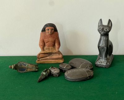 une petite statue représentant un chat et d'autres objets posés sur une table