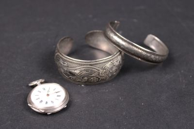 deux bagues en argent et une montre en argent posées sur une surface noire