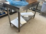 a stainless steel table in the middle of a kitchen