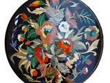 a black plate with colorful flowers and leaves on it