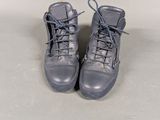 pair of gray leather boots with laces on them on a white surface