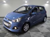 une voiture bleue est garée dans une pièce au sol à carreaux