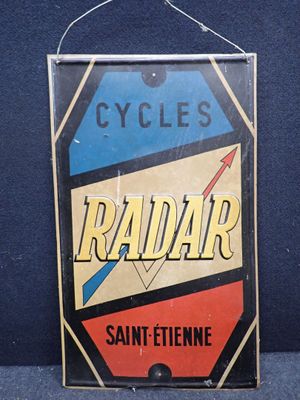 une enseigne Radiar vintage accrochée à un mur bleu dans une pièce
