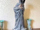 une statue représentant une femme debout sur une table, avec deux vases