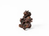 une petite figurine en bois représentant un singe tenant une guitare