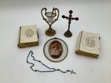 un chapelet, un livre, une bougie et une photo posés sur une table