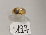 gros plan d'une bague en or et diamants sur une surface blanche