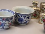 three cups and a vase sitting on a table