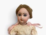 a close up of a doll on a white surface