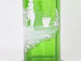 a green glass vase with a picture of a woman on it
