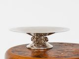 a silver plate on top of a wooden stand