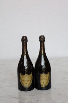two bottles of champagne sitting on top of a marble counter top