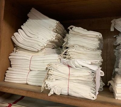 de nombreuses piles de serviettes blanches pliées sur une étagère