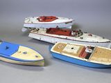 trois petits bateaux jouets posés les uns à côté des autres sur une table
